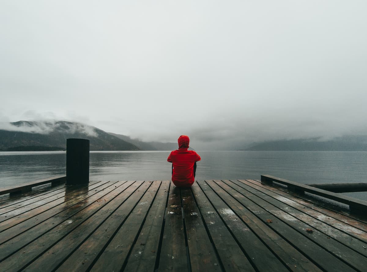 A lonely person sat down looking at the the ocean