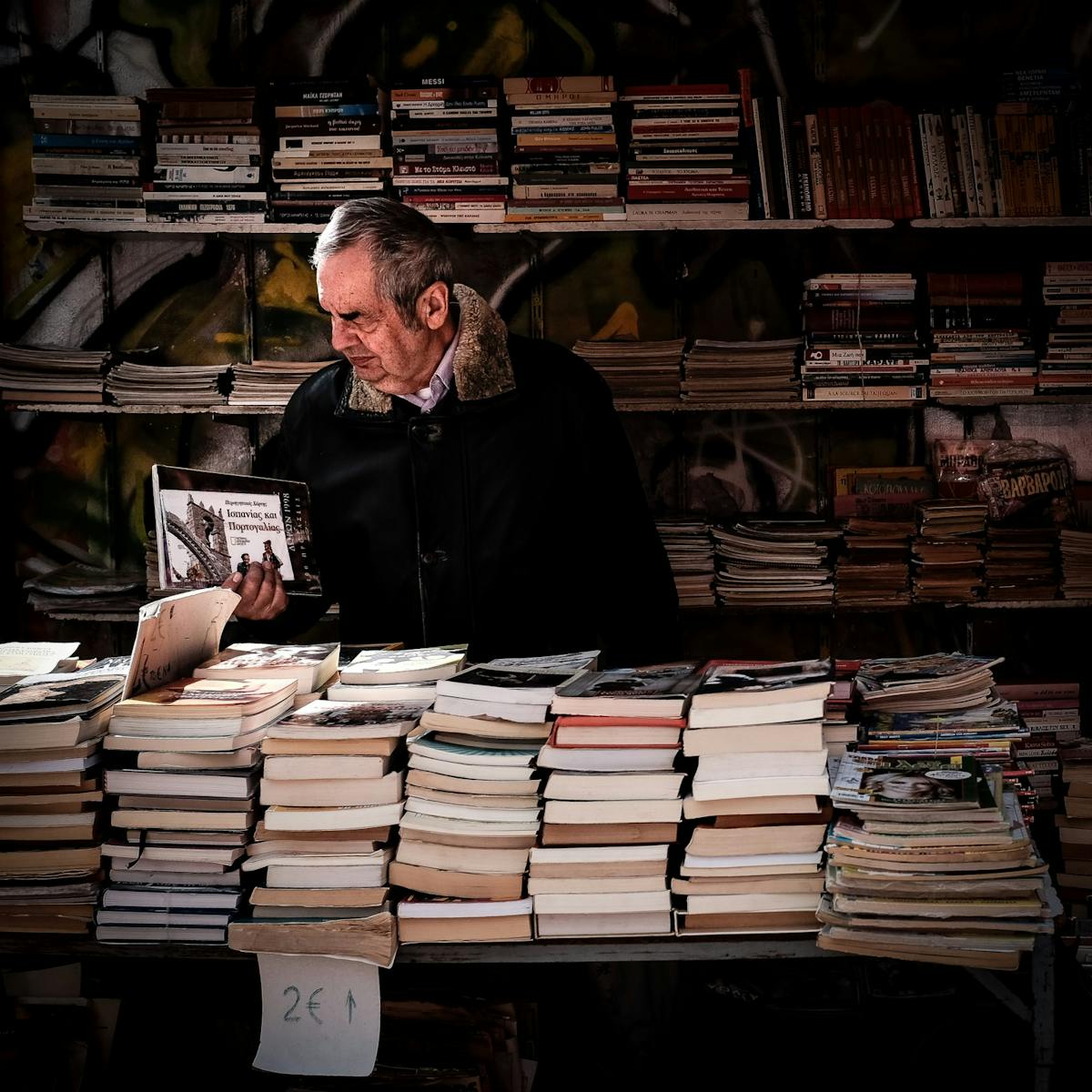 An old man with piles of books